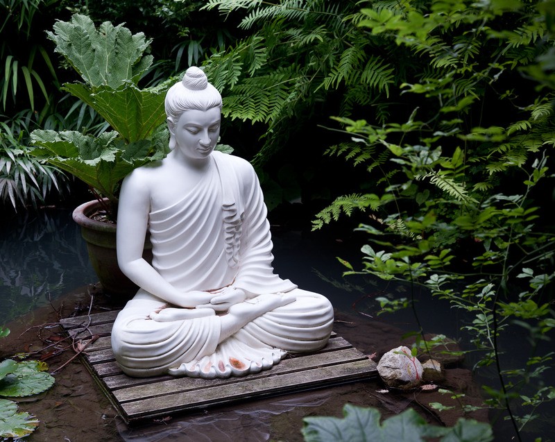 Tuinposter 'Zittende boeddha bij vijver'